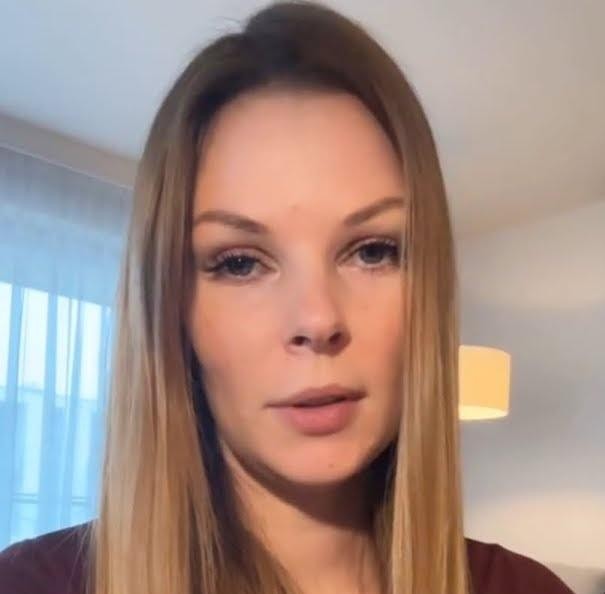 Małgorzata Tomaszewska w dynamicznej pozie na planie telewizyjnym, prezentująca program.