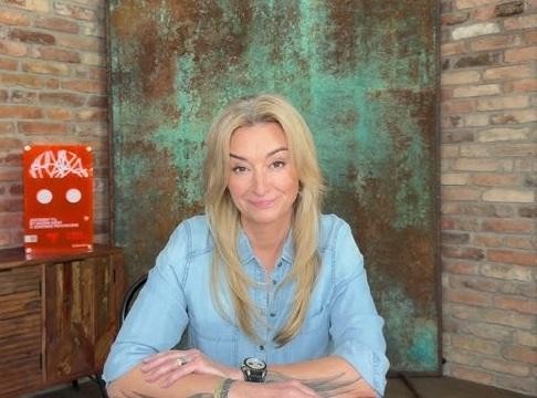 Martyna Wojciechowska na tle egzotycznego krajobrazu, symbolizującego jej podróże i osiągnięcia w programie