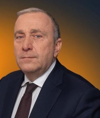 Grzegorz Schetyna podczas publicznego wystąpienia, aktywnie gestykulujący, co symbolizuje jego zaangażowanie w dialog polityczny i interakcję z wyborcami.