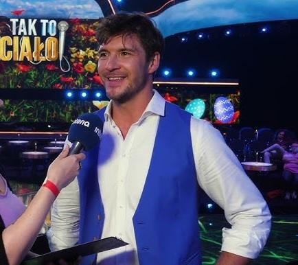 Scena teatralna z pojedynczym aktorem w świetle reflektorów, symbolizująca edukację i rozwój artystyczny.