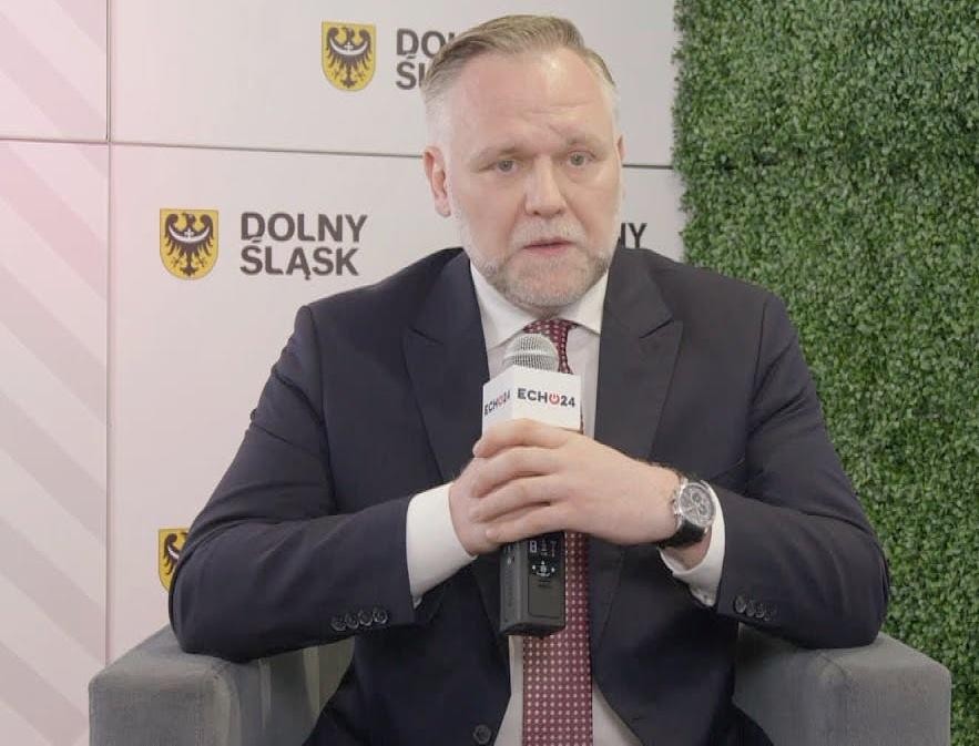 Grafika symbolizująca rozwój gospodarczy i bezpieczeństwo Polski, z elementami wykresu giełdowego i tarczy ochronnej.