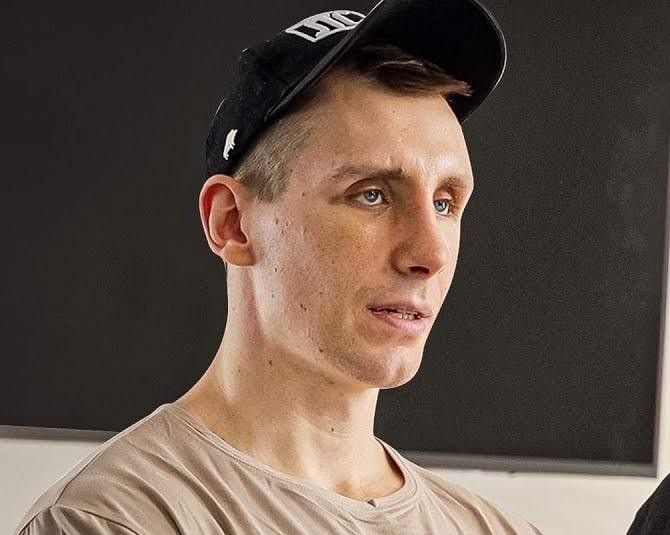 Michał Owczarzak (Owca WK) prezentujący imponującą muskulaturę ramion i pleców, symbolizującą siłę i dyscyplinę w kulturystyce.