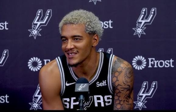 Jeremy Sochan w koszulce San Antonio Spurs, w trakcie meczu NBA, wykonujący dynamiczną akcję na parkiecie.