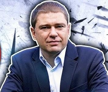 Piotr Szumlewicz przemawiający na wiecu związkowym lub debacie publicznej, z zaangażowaniem gestykulujący, w tle widoczny tłum ludzi.