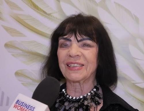 Uśmiechnięta Sława Przybylska, być może trzymająca mikrofon lub patrząca na zdjęcie, z ciepłym, nostalgicznym wyrazem twarzy.