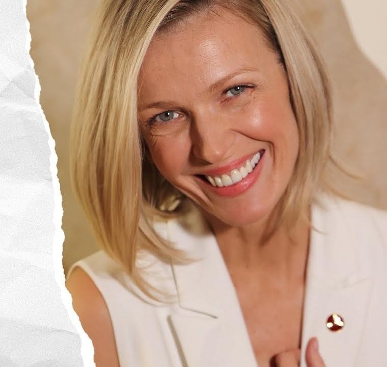 Magda Mołek uśmiechnięta, trzymająca w dłoni jedną ze swoich nagród, na rozmytym, celebratorym tle.