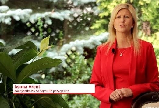 Iwona Arent przemawiająca z pasją na mównicy, w tle zamazane postaci słuchaczy lub wnętrze sali sejmowej.