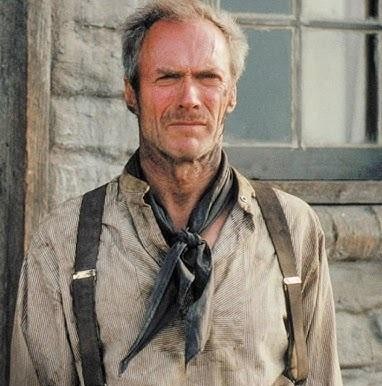 Portret Clinta Eastwooda w roli reżysera, z zamyślonym wyrazem twarzy, na tle planu filmowego.